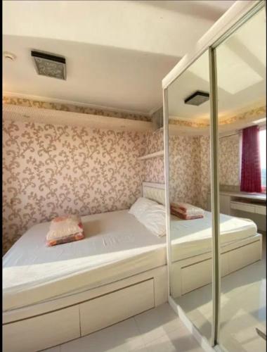 雅加达Sewa Apartemen Kalibata City by The Best的一间卧室配有两张床和镜子