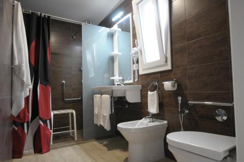 新锡里马里纳Castroboleto Village的一间带卫生间、水槽和镜子的浴室