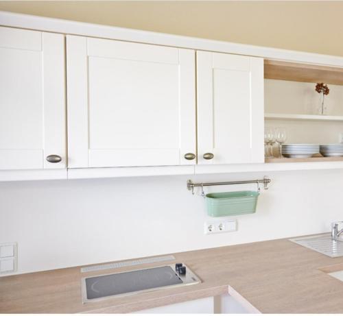 塔勒Dambachhaus Thale的厨房配有白色橱柜和水槽