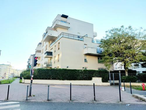 塞尔吉Cosy Home 1, Cergy Le Haut, 6 personnes, 3 min gare, 30 min Paris, parking privé的一条城市街道上的白色大建筑