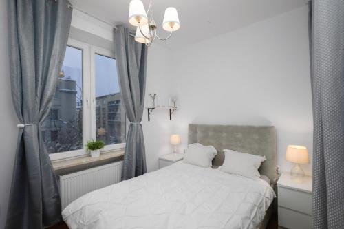 克拉科夫Black&White的卧室配有白色的床和窗户。