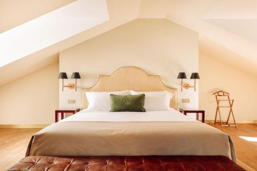 里斯本Hotel das Amoreiras - Small Luxury Hotels of the World的一间卧室配有一张带绿色枕头的大床