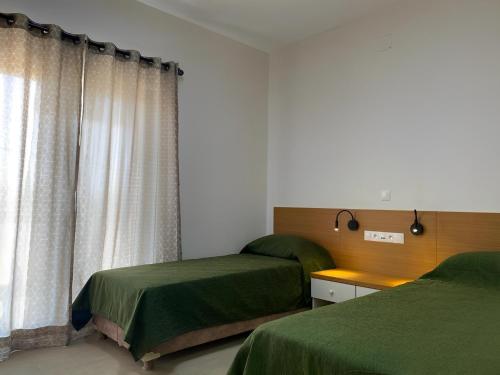 尼亚美Le Lézard Vert, Maison d'Affair à Niamey的一间卧室设有两张床和窗户。