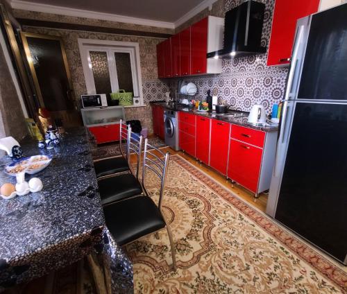 塔什干Heyvah - Guest House in Tashkent的厨房配有红色橱柜和黑色冰箱