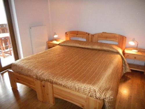 BianzoneAPPARTAMENTO Villa Isabella的一间卧室配有木床和2个床头柜
