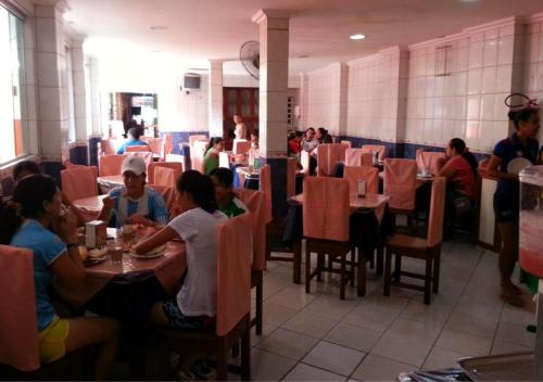 贝伦Hotel Paraiso Belém的一群坐在餐厅桌子上的人