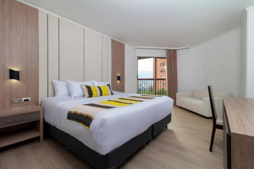 麦德林麦德林-贝尔福-达恩卡尔顿酒店的一间卧室配有一张大床和一张沙发