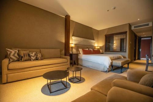 拉库布蕾Pueblo Nativo Resort Golf & Spa的酒店客房,配有床和沙发