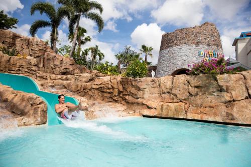 奥兰多洛伊斯蓝宝石瀑布度假酒店的一个人在水上公园里骑水滑梯