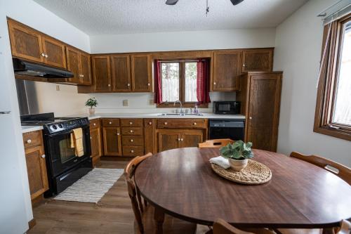 DeerwoodCuyuna Lakes Stay的厨房配有木制橱柜和木桌。