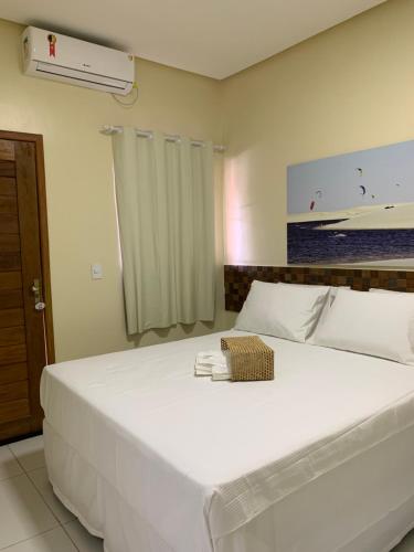 Paulino NevesPOUSADA DOS LAGOS的卧室配有一张大白色的床和风扇