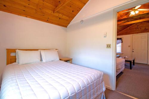 威尔斯海滩半月小屋汽车旅馆的卧室配有白色的床