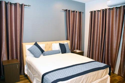南迪Breeze Apartments的一间卧室配有棕色窗帘的床
