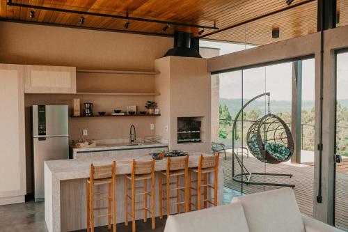 南卡希亚斯Casas na montanha - Villa Montegrappa的一个带桌椅和大窗户的厨房
