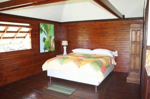 乌图罗阿赖阿特阿岛机场简易别墅度假屋的卧室配有木墙内的一张床