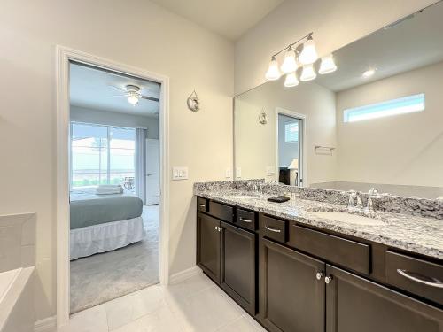 达文波特Windsor Island Vacation Pool Home的一间带两个盥洗盆和大镜子的浴室