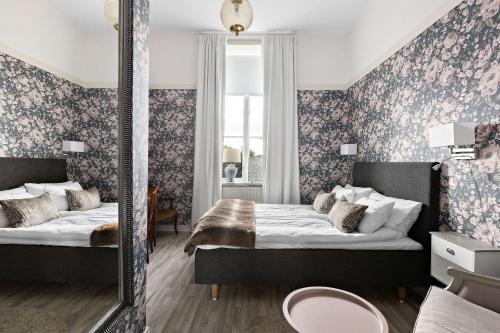 诺拉Nora Stadshotell, Sure Hotel Collection by Best Western的一间卧室配有两张床和镜子