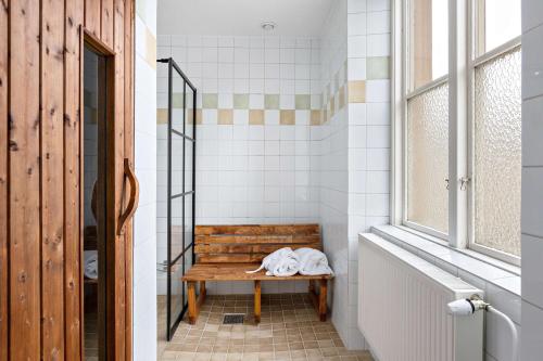 诺拉Nora Stadshotell, Sure Hotel Collection by Best Western的窗户浴室内的木凳
