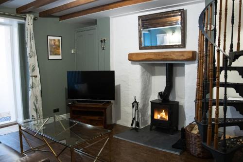 凯尔索The Burrow的客厅设有壁炉和电视。