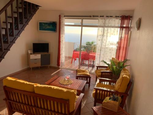 波尔兰特PARADIS AU SOLEIL, vue panoramique sur mer的客厅配有沙发和桌子