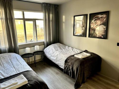 凯夫拉维克Elegant apartment in Keflavík的一间卧室设有两张床和窗户。
