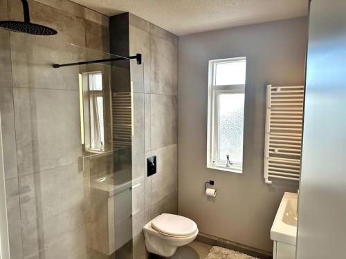 凯夫拉维克Elegant apartment in Keflavík的浴室配有卫生间、淋浴和盥洗盆。