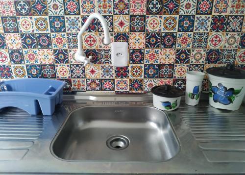 皮涅拉Loft/APTO em Praia da Pinheira的带水槽的厨房台面和瓷砖墙