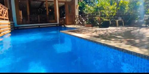 瓜鲁雅Casa elegante em condomínio的房子前面的蓝色游泳池