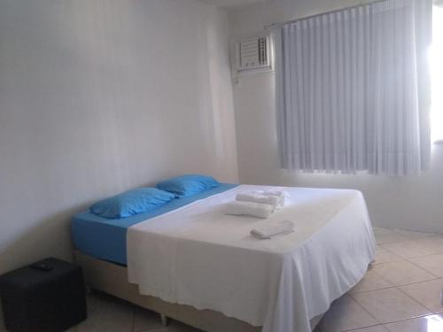 维拉维尔哈Kitnet Itapuã的一间卧室配有一张带蓝色枕头的床和一张桌子