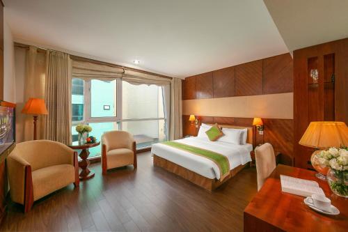 河内Emerald Boutique Hotel的酒店客房带一张床、一张桌子和椅子