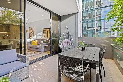布里斯班Southbank Heart+2 Bed+Balcony+Pool+Gym+Free Wifi的天井配有桌椅和沙发。