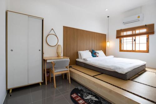 Ban Muang MaiVilla Sunrise Garden A181的一间卧室配有一张床、一张桌子和一把椅子
