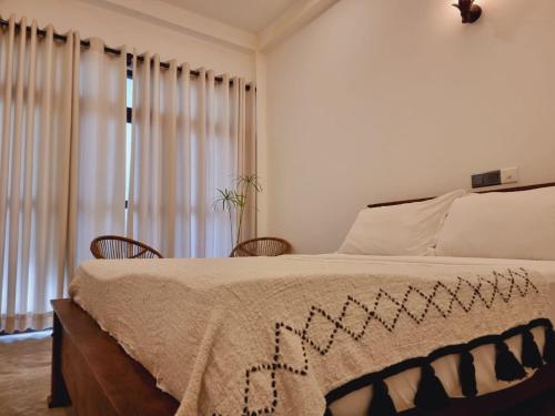 阿杭格默Sandil Surf house的一间卧室配有一张大床和两把椅子