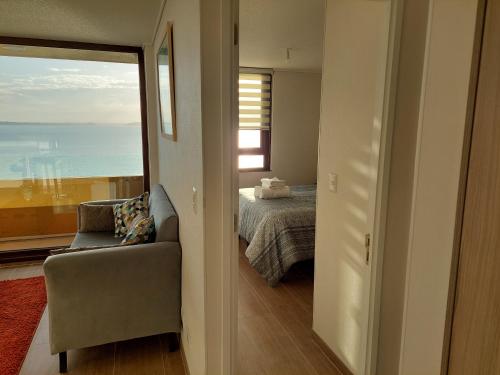 蒙特港Departamento con preciosa vista al mar y ciudad的卧室配有床、椅子和窗户。