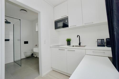 格齐斯Motel by Maier Götzis- kontaktloser Check-in的白色的厨房设有水槽和卫生间