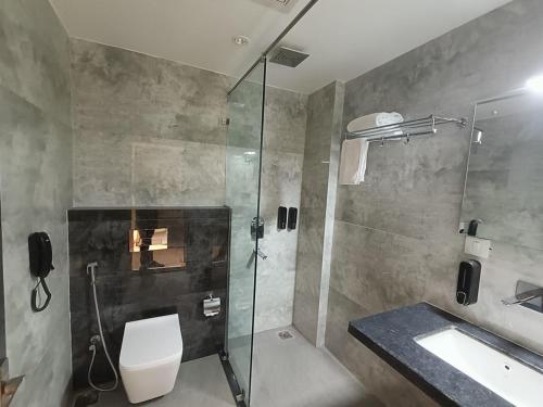 迪布鲁加尔HOTEL GOLDEN ORCHID的带淋浴、卫生间和盥洗盆的浴室