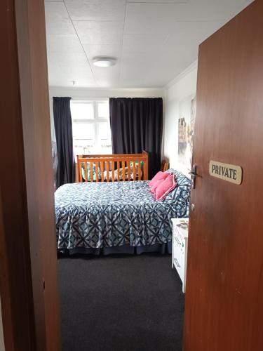 格雷默斯Ahaura Hotel的一间卧室配有一张带蓝色棉被的床