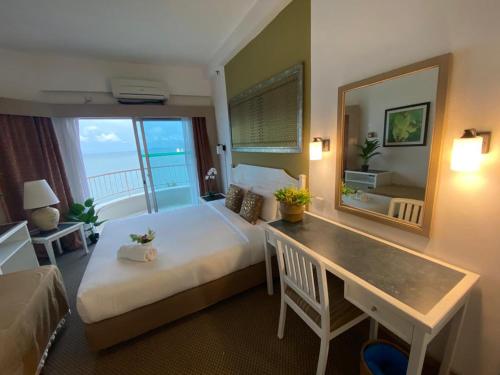 丹绒武雅Seaview Deluxe@Rainbow Paradise Tg Bungah 4-6pax的酒店客房配有床、桌子和镜子