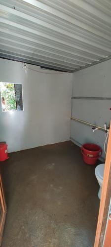 马迪凯里Coorg River Rock Camping的一间带两个卫生间和红色桶的浴室
