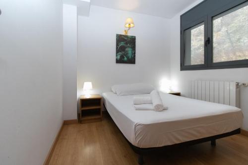 卡尼略卡尼略3000公寓的一间卧室设有两张床和窗户。