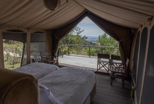 马赛马拉Mara Elatia Camp的一个带两张床的帐篷,享有门廊的景色