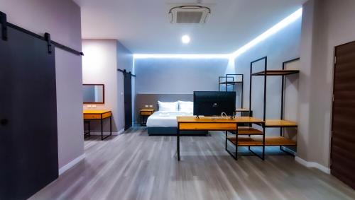 万象The Riva Vientiane Hotel的一间卧室配有一张床和一张带电脑的书桌