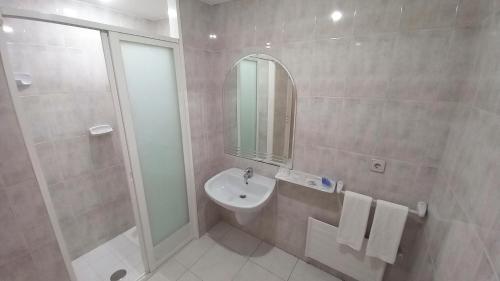 TeoMotel Montecarlo的一间带水槽、淋浴和镜子的浴室