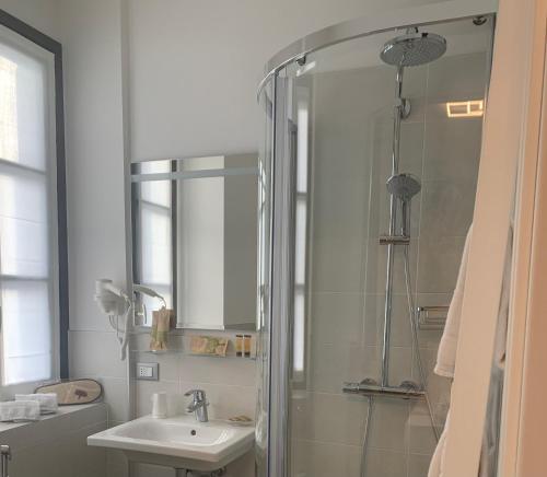 松德里奥Guest House Le Cassandre的带淋浴、盥洗盆和镜子的浴室