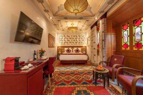 马拉喀什阿拉比庄园酒店的酒店客房带一张床、一张桌子和椅子