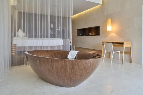 EnnetbadenLimmathof Baden - Boutique Haus & Spa的一个带桌子的浴室内的大型木制浴缸