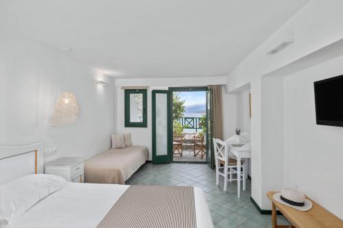 阿梅尼斯蒂斯埃罗费里海滩酒店的酒店客房带一张床、一张桌子和椅子