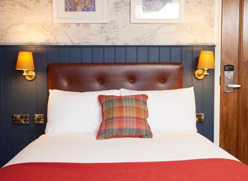 莱斯特Castle Hotel by Chef & Brewer Collection的卧室配有一张带白色床单和拼盘枕头的床。