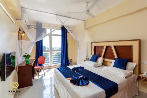 恩德培Pulickal Airport Hotel的酒店客房设有一张大床和一台电视。