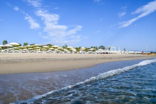马里纳斯基亚沃尼亚Salice Resort的海滩上设有椅子和遮阳伞,还有大海